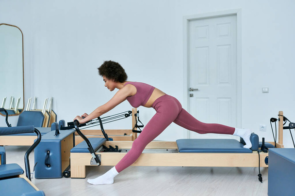 Женщина в розовом топе и леггинсах энергично выполняет упражнения. - Фото, изображение