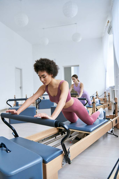 Attractive woman skillfully exercising next to her friend. - Foto, Imagem