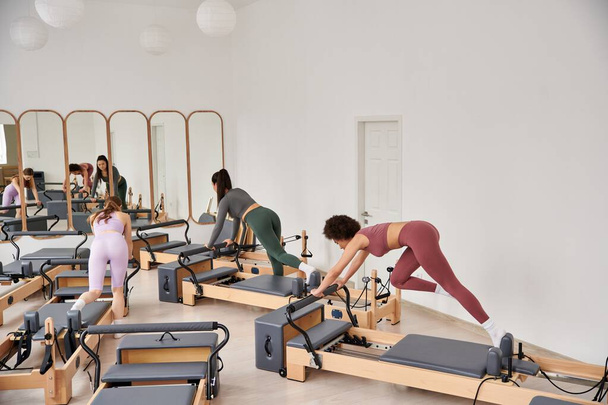 Eine Gruppe sportlicher Frauen beim Pilates-Training im Fitnessstudio. - Foto, Bild