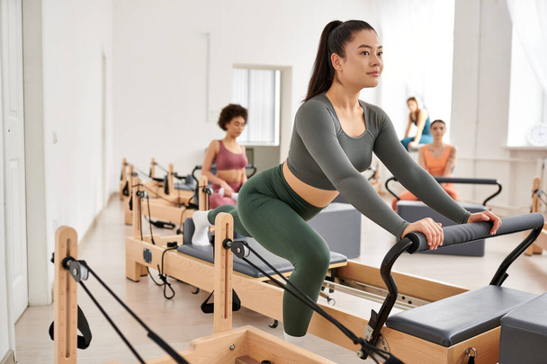 Attractive group of sporty women engaging in a pilates workout at the gym. - Foto, imagen