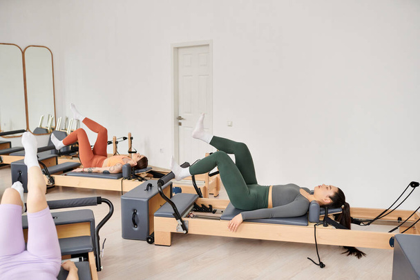 Attractive women engaging in a pilates workout at the gym. - Фото, изображение