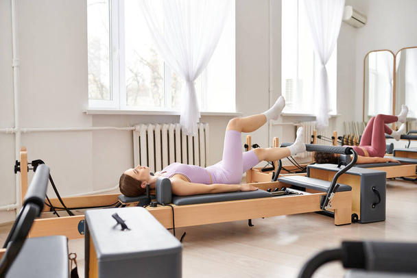 Jolies femmes se livrant à un entraînement de pilates à la salle de gym. - Photo, image
