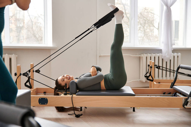 Una donna sportiva dimostra grazia e forza mentre esegue un perno durante una lezione di pilates. - Foto, immagini
