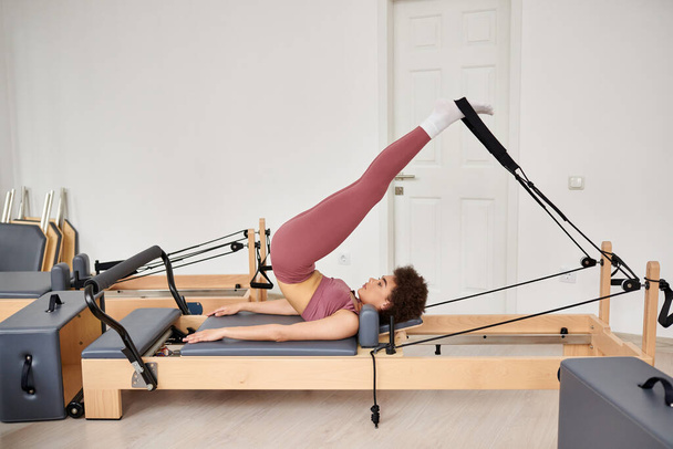 Baştan çıkarıcı kadın, pilates dersi sırasında incelikle egzersiz yapar.. - Fotoğraf, Görsel