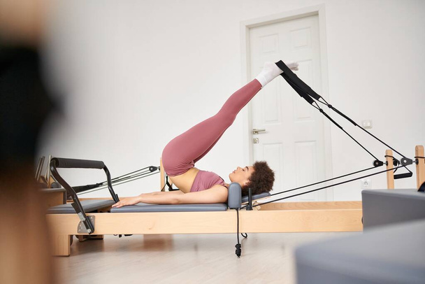 Alluring woman gracefully performs exercises during a pilates lesson. - Foto, afbeelding