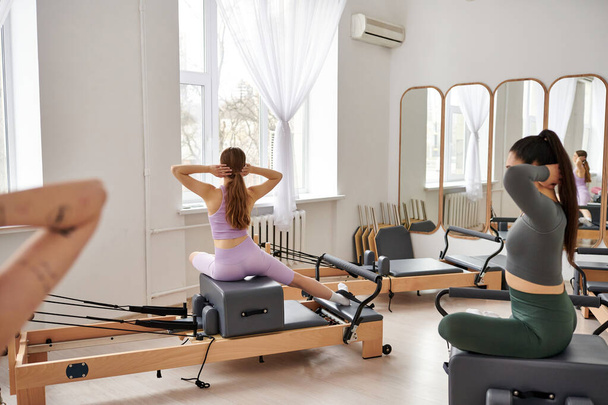 Mujeres deportivas realizando ejercicios dinámicos en un entorno de gimnasio animado. - Foto, imagen