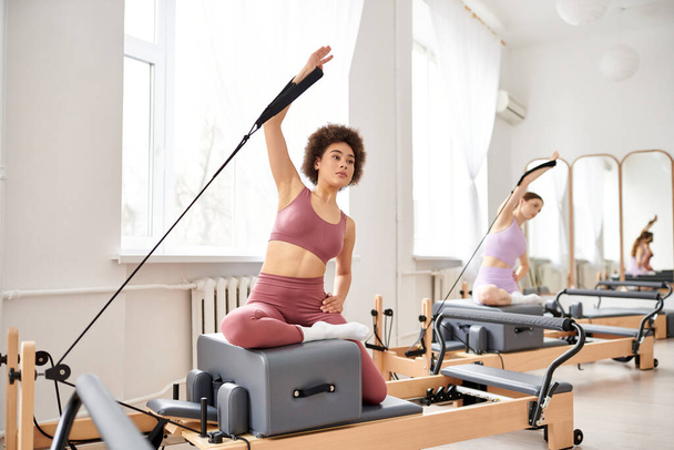 Alluring women engage in a pilates class, focusing on flexibility and core strength. - Foto, afbeelding