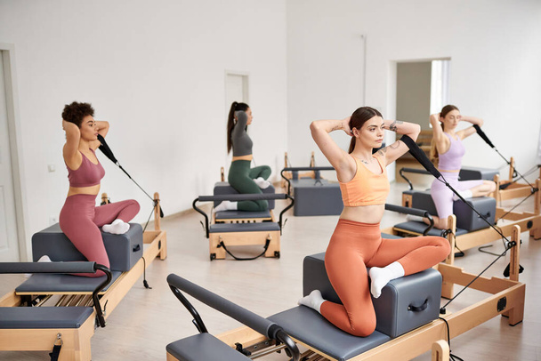 Eine Gruppe sportlicher Frauen macht Pilates-Übungen im Fitnessstudio. - Foto, Bild