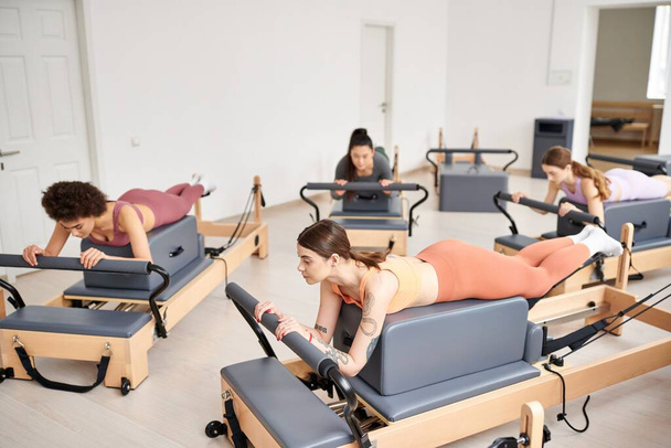 Sportos nők részt vesznek egy Pilates ülésen egy világos szobában. - Fotó, kép