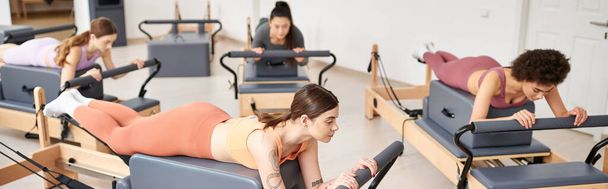 Un gruppo di donne abbastanza sportive impegnate in esercizi durante una lezione di pilates in palestra. - Foto, immagini