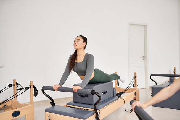 Appealing woman exercising during a pilates lesson. - Photo, Image