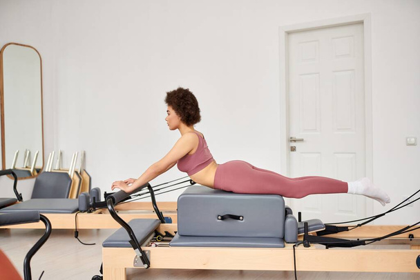 Mujer atractiva haciendo ejercicio durante una lección de pilates. - Foto, imagen