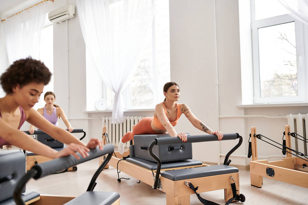 Appealing women in sportswear during pilates in a gym together. - Photo, Image