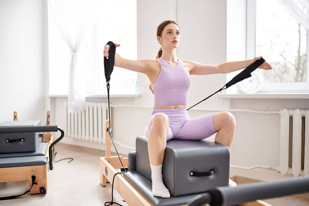 Appealing woman in sportwear exercising on pilates lesson. - Foto, immagini