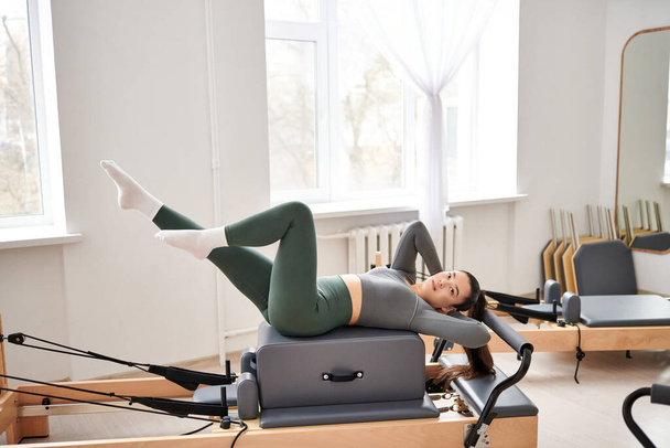 Sportliche Frau in kuscheliger Kleidung trainiert aktiv Pilates. - Foto, Bild