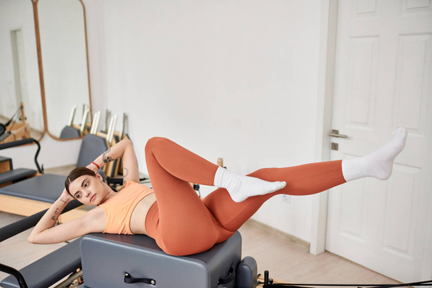 Attractive woman in comfy sportswear practising during pilates lesson. - Photo, Image