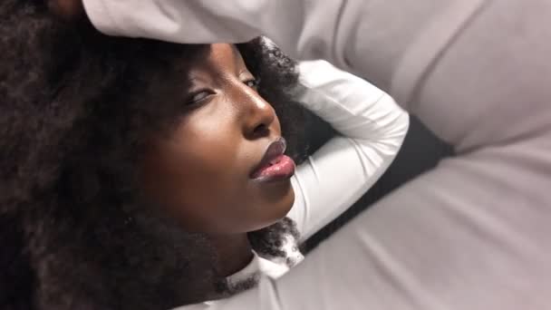 In a captivating display of allure, this clip showcases a young African American woman in a sultry, seductive pose within a modern setting. The transition between the scenes accentuates her enchanting - Footage, Video