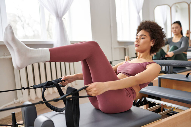 Alluring women gracefully practicing pilates in a gym together. - Photo, Image