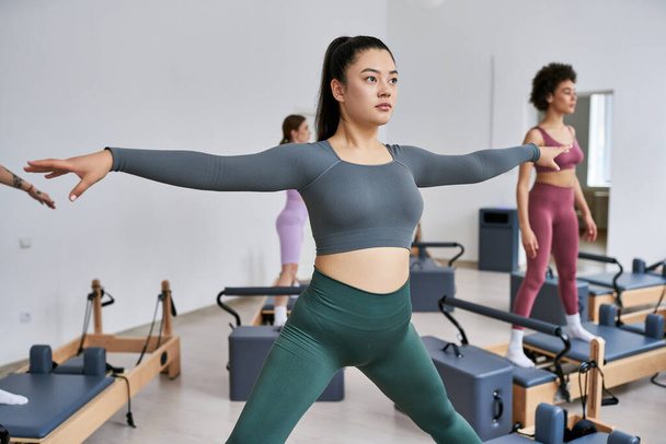 Un gruppo di donne piuttosto sportive impegnate in una vivace classe di pilates. - Foto, immagini