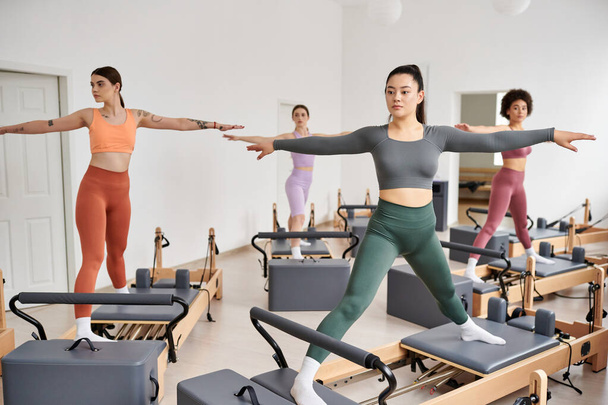 A group of pretty sporty women gracefully practicing pilates in a class. - Фото, изображение