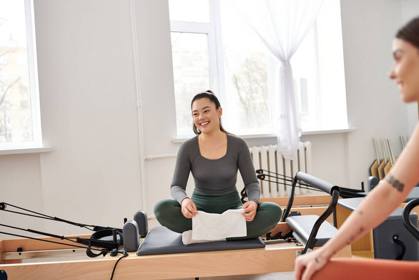 Attractive women taking break during pilates lesson in gym. - Photo, Image