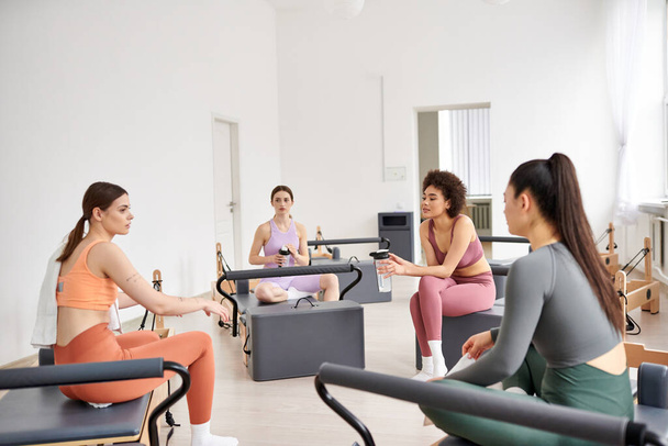 Fit women spending time together on pilates lesson in gym, relaxing. - Photo, Image