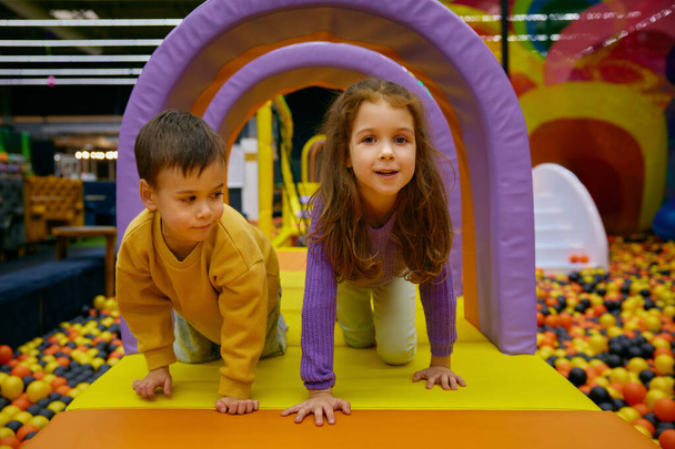 Irmãozinho e irmã positivo crianças brincando no parque indoor. Despreocupada diversão tempo, diversão aventura na atração no centro do jogo - Foto, Imagem