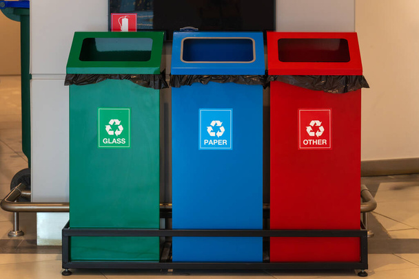 Lähikuva vihreä, sininen, ja punainen roskakorit erillistä hävittämistä lasi, paperi, ja muut roskat myymälässä. Asianmukaisen jätehuollon käsite. - Valokuva, kuva