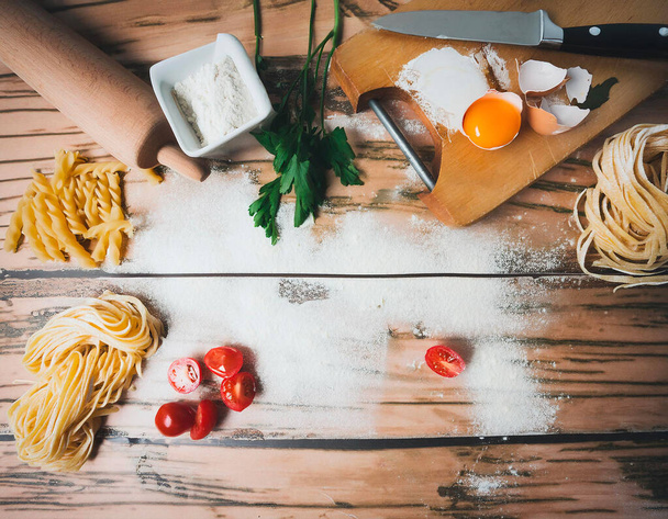  ингредиенты для fare la pasta, farina, su un tagliere di legno  - Фото, изображение