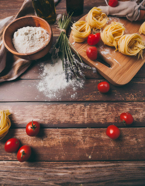  ingredienti per fare la pasta, farina, su un tagliere di legno  - Foto, imagen
