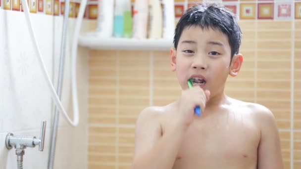 Jovem asiático menino escovação dentes no banheiro
 - Filmagem, Vídeo