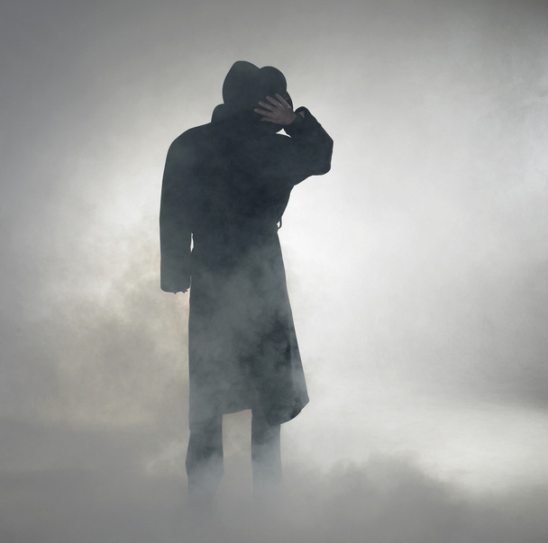 Mulher vestindo casaco de trincheira e de pé no nevoeiro
 - Foto, Imagem
