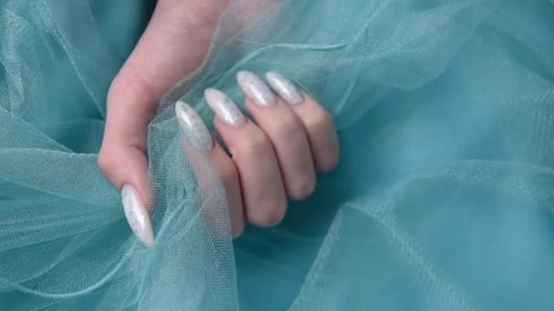 Female hands with blue nail design on blue pastel background. Blue nail polish manicure.  - Footage, Video