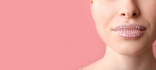 Mooie jonge vrouw met markering op lippen tegen roze achtergrond met ruimte voor tekst, close-up. Cosmetologisch concept - Foto, afbeelding