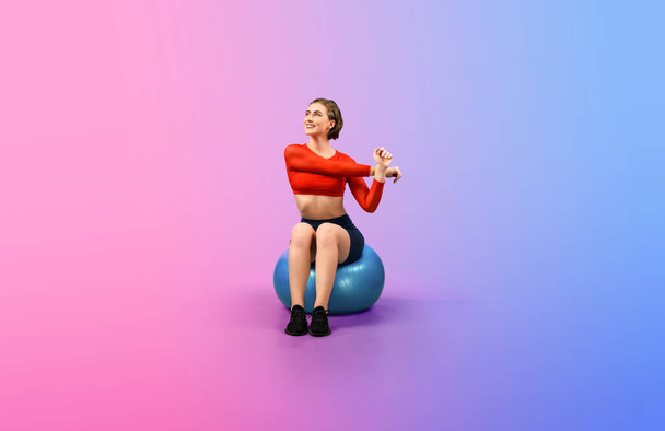 Gaieté pleine longueur du corps tourné athlétique et sportive jeune femme avec ballon d'exercice de remise en forme en posture debout sur fond isolé. Mode de vie sain et actif. - Photo, image