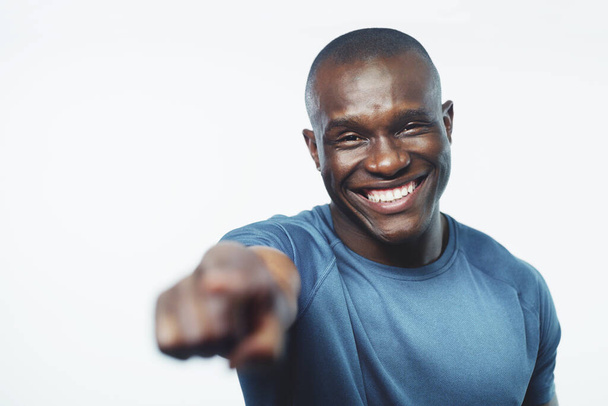 Happy, portrait and black man pointing to you with fitness for sign up, join or opportunity on a white studio background. Face of young African or male person with smile for selection, choice or pick. - Photo, Image
