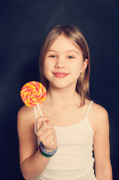 Young girl with lollipop on background - Photo, Image