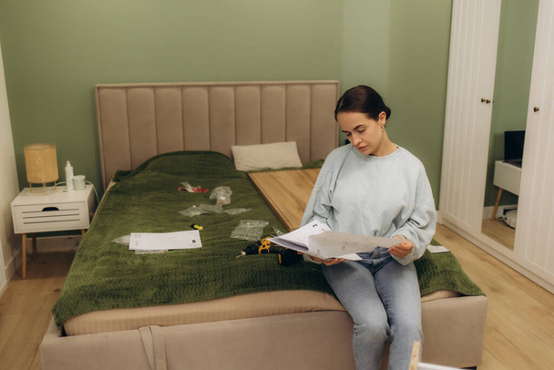 Stresli kadın mobilya montajı ve ev geliştirme talimatlarını okurken hayal kırıklığına uğramış ve kafası karışmış hissediyor - Fotoğraf, Görsel