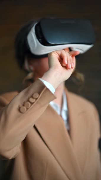 Nainen elehtii käyttäessään Virtual Reality kuulokkeita toimistossa. Pystysuora - Materiaali, video