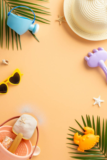 Živý vertikální sortiment letních plážových předmětů, včetně modré plechovky na zavlažování, slaměného klobouku, slunečních brýlí a písečných hraček s tropickými listy a hvězdicovitými akcenty na teplém pastelovém pozadí - Fotografie, Obrázek