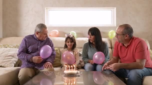Video van een gelukkig gezin zingen Gelukkige verjaardag zittend op een bank - Video