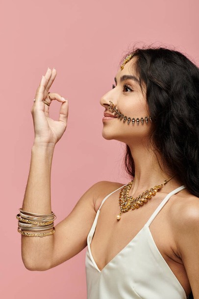 Jonge indiaanse vrouw vitrines gouden sieraden met de hand gebaar. - Foto, afbeelding