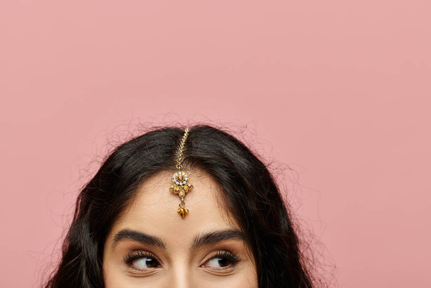Femme indienne élégante présentant une magnifique tiare en or. - Photo, image