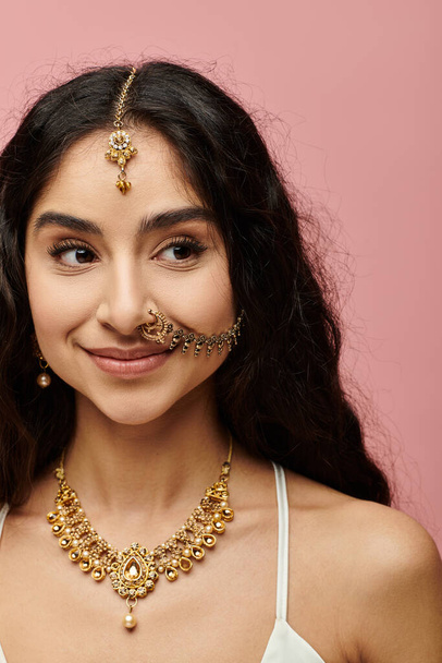 Oszałamiająca Hinduska kobieta pewnie pokazuje swój złoty naszyjnik i kolczyki. - Zdjęcie, obraz