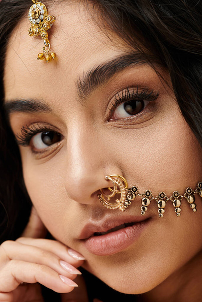 Een boeiende jonge indiaanse vrouw toont trots haar ingewikkelde neus piercing. - Foto, afbeelding