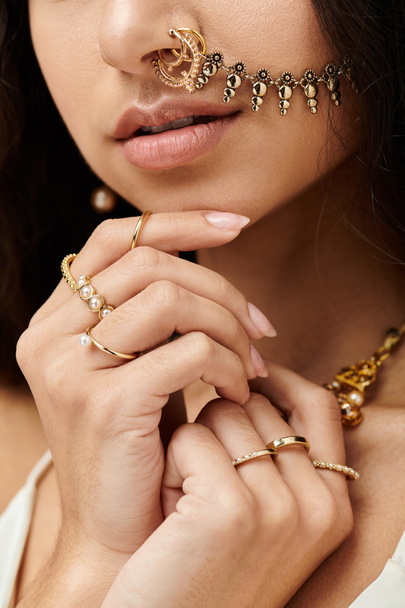 A young indian woman exudes beauty and confidence with a shimmering gold nose ring. - Photo, Image