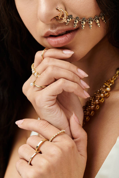 A stylish young indian woman proudly wears a shimmering gold nose ring. - Photo, Image