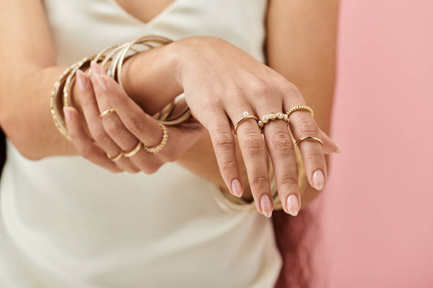 Μια Ινδιάνα κρατά ένα χρυσό δαχτυλίδι στο χέρι της, επιδεικνύοντας κομψότητα και ομορφιά.. - Φωτογραφία, εικόνα