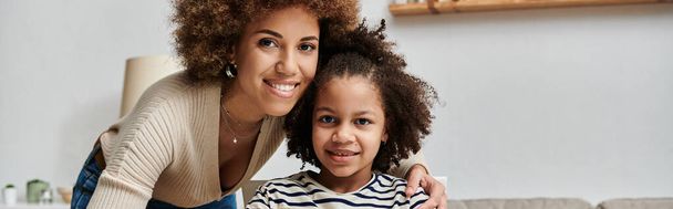 Boldog afro-amerikai anya és lánya pózol egy közös kép, bemutatja a szeretet és a kötődés otthon. - Fotó, kép