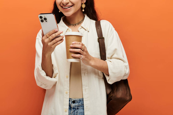 indische Frau Multitasking mit Kaffee und Telefon in der Hand. - Foto, Bild